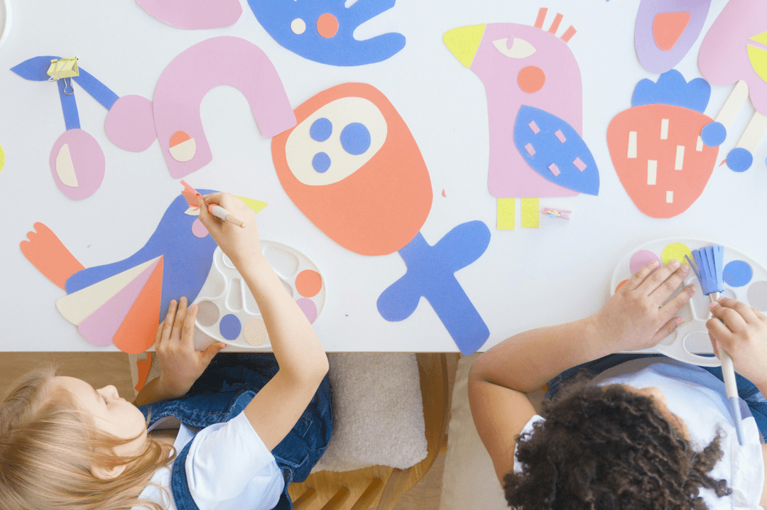 Children creating artwork with coloured paper